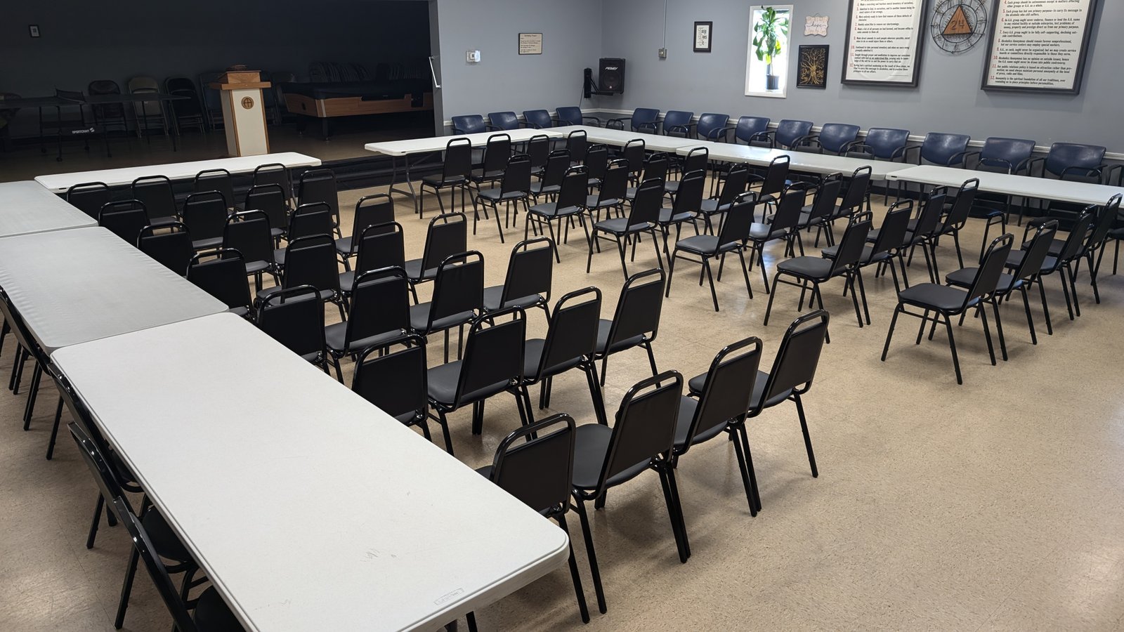 The 13th Street Clubhouse meeting room with chairs, tables, and the stage
